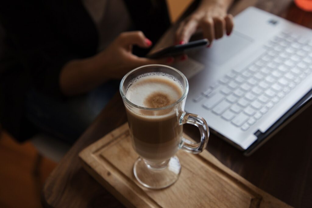 A founder with a coffee, calm and focused, reviewing results on a laptop in the morning