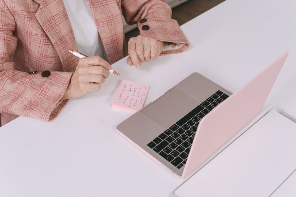 A person reading through a short printed list of company names and notes at a desk