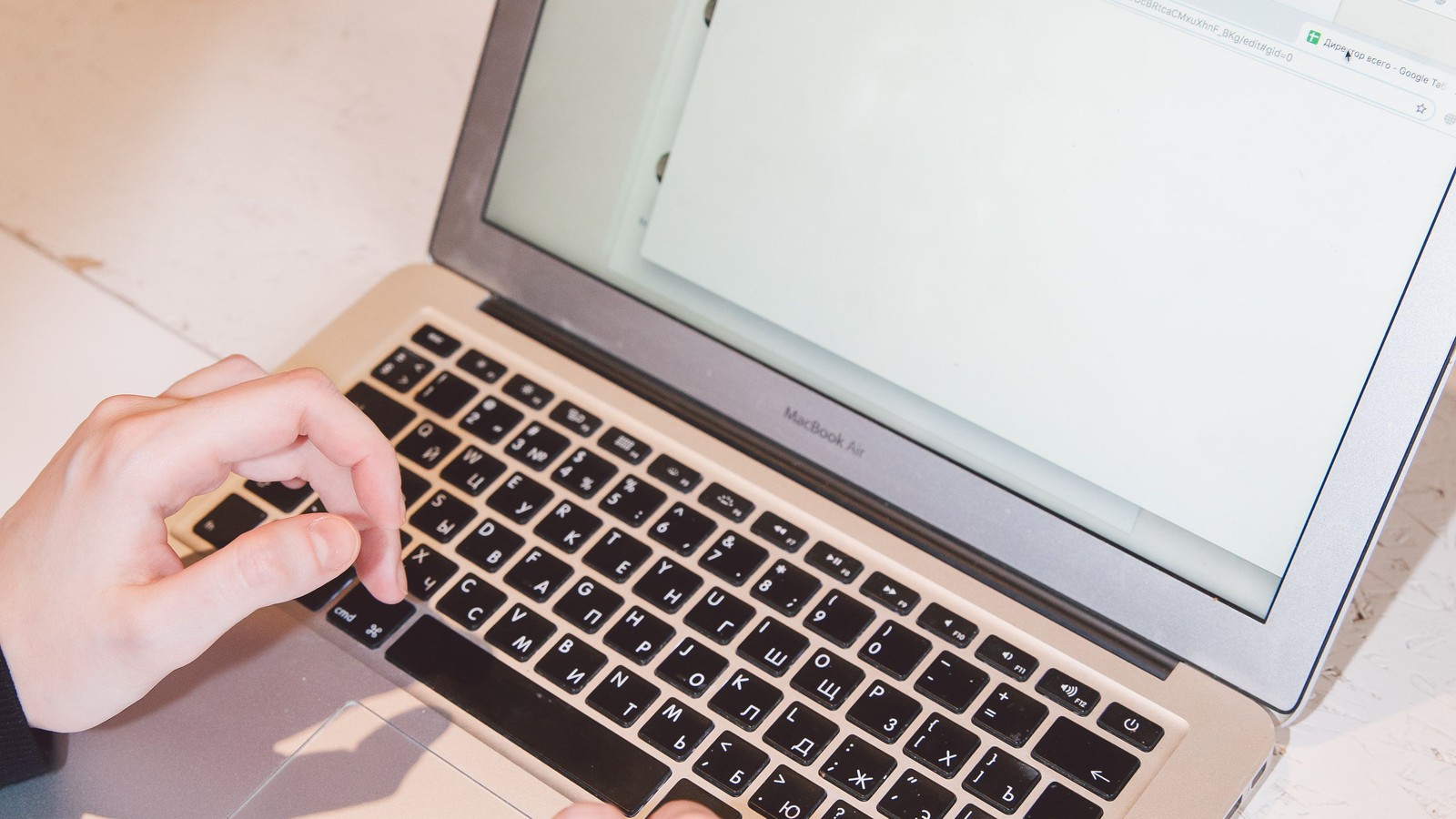 Close up of hands typing on a laptop at an office desk, suggesting the cold email writing process these lessons actually apply to