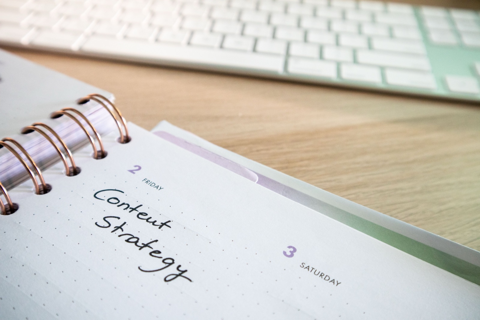 Notebook page reading Content Strategy next to a keyboard