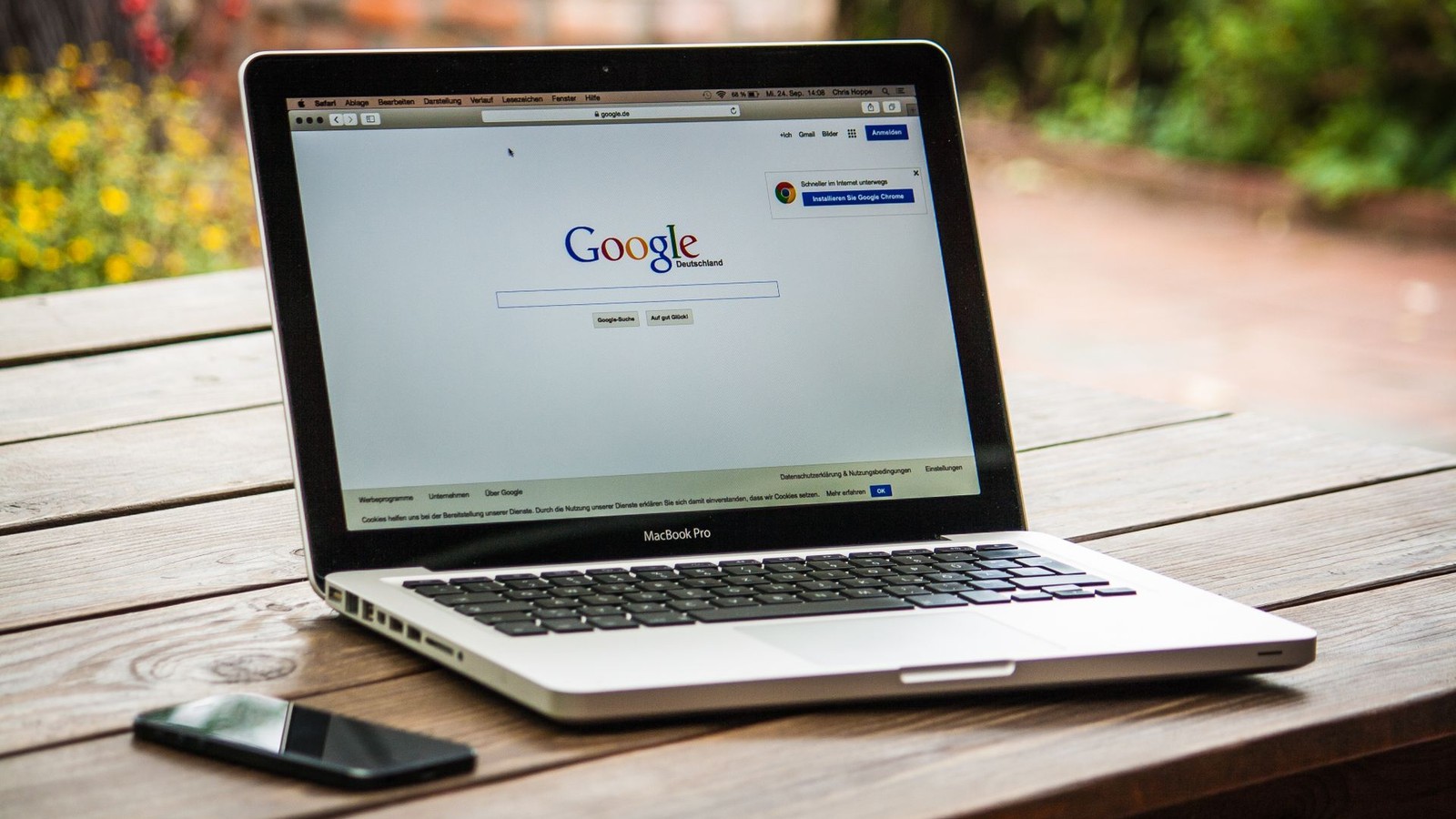 A laptop open to a Google search page on an outdoor table