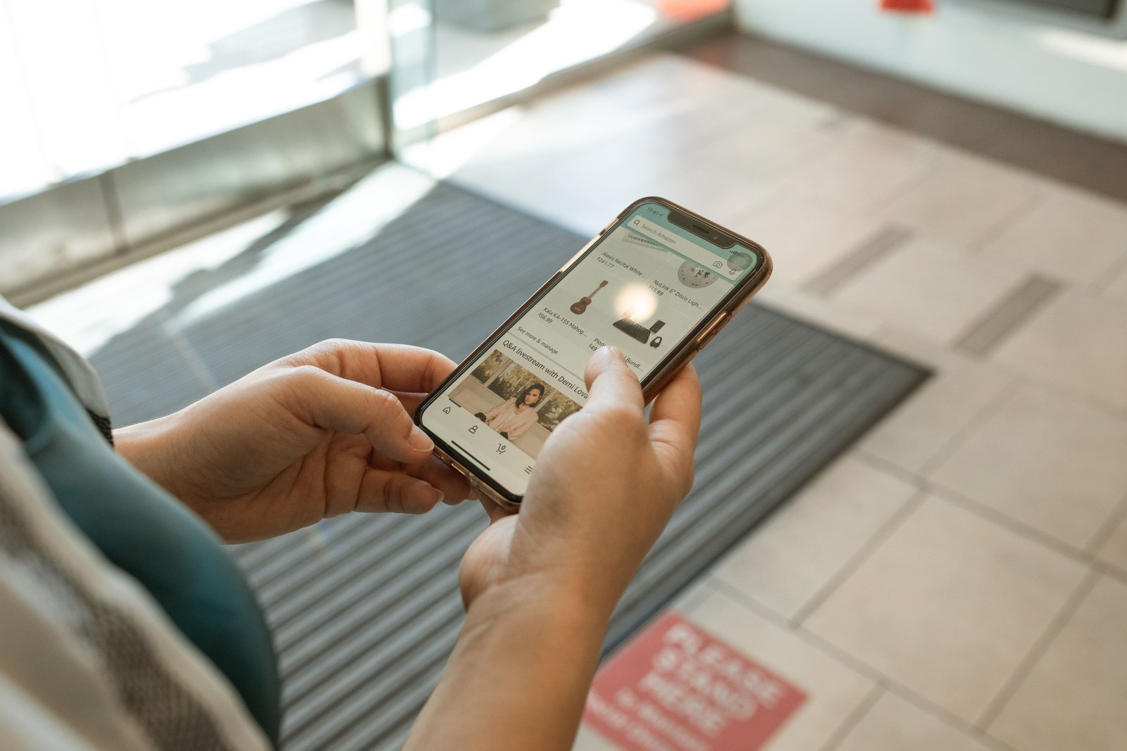 A person holding a phone showing an AI generated answer with citations, a laptop open beside it