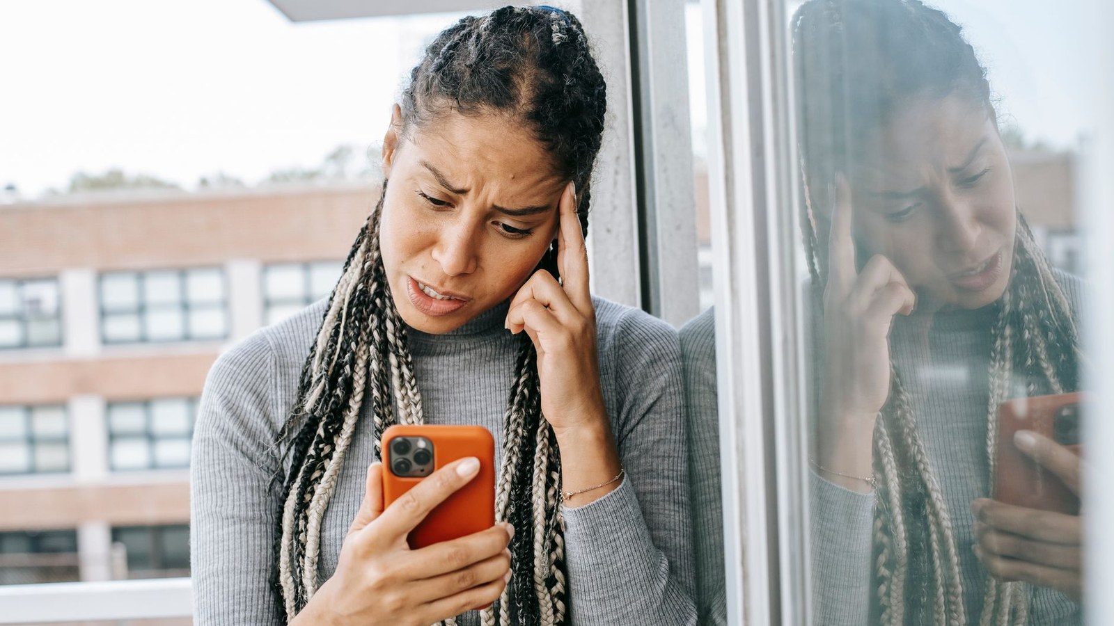 A person looking frustrated while checking her phone