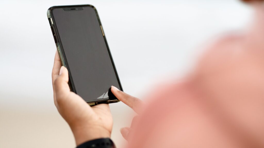 A person checking a phone screen outdoors, the kind of quick decision moment a donation page has to win