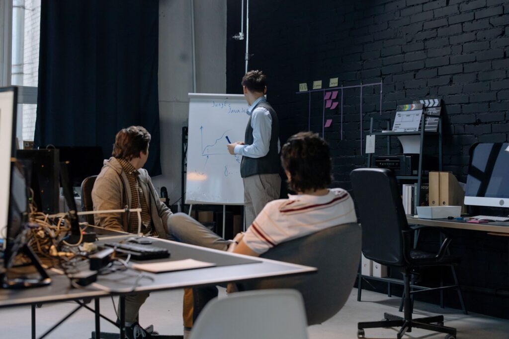 A small team looking at a whiteboard together, planning next steps