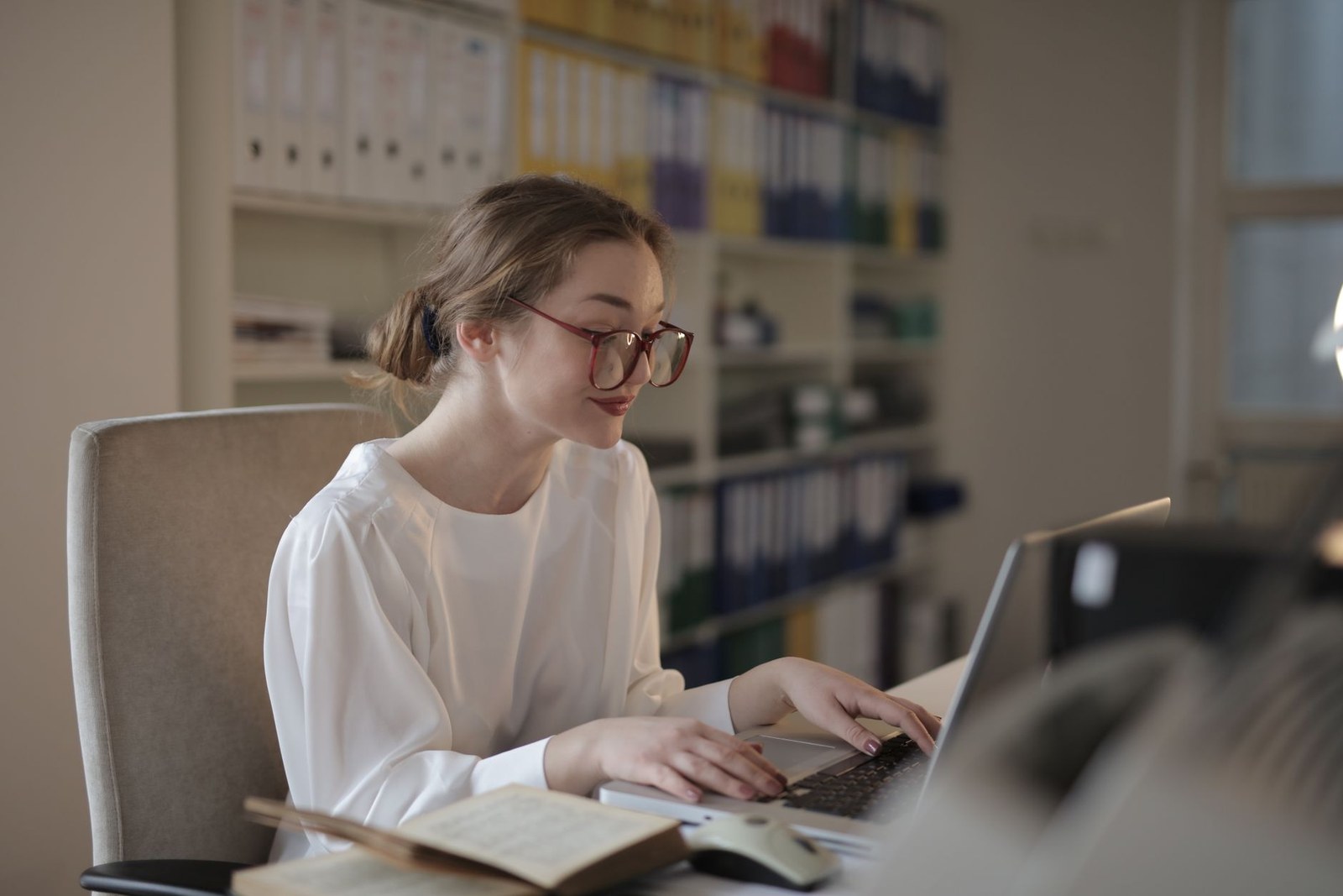 A small business owner working on her laptop at an office desk