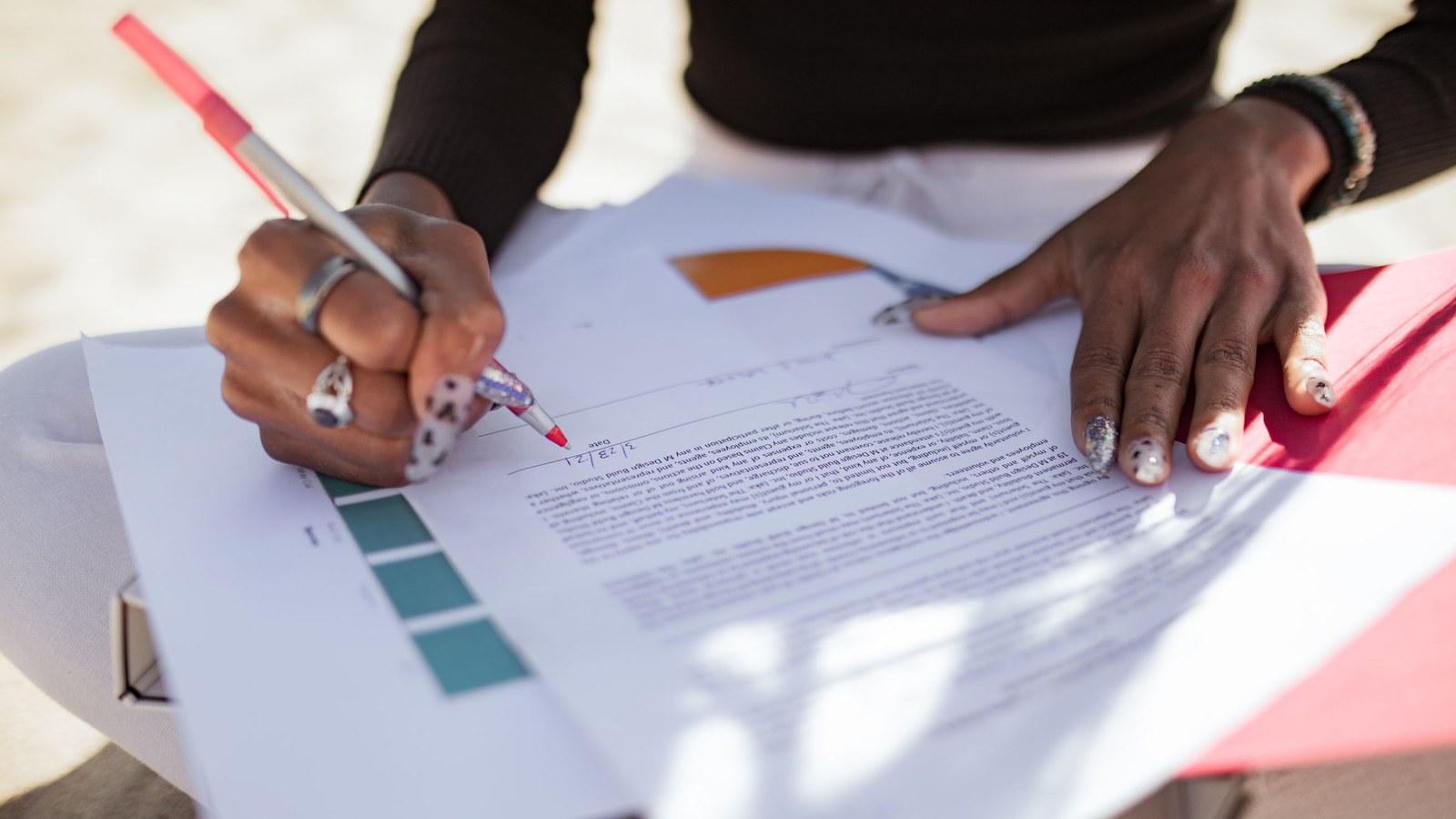 A writer marking up a printed draft with a red pen